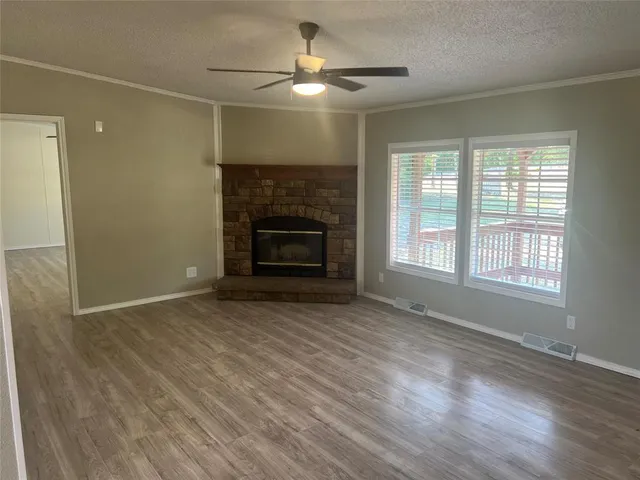 wooden floor fireplace and windows in an empty room