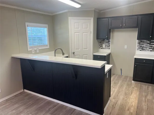 a kitchen with a sink a refrigerator and wooden cabinets