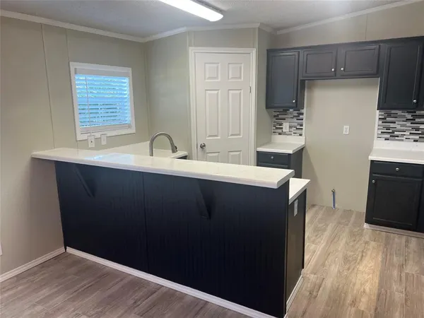 a kitchen with a sink a refrigerator and wooden cabinets