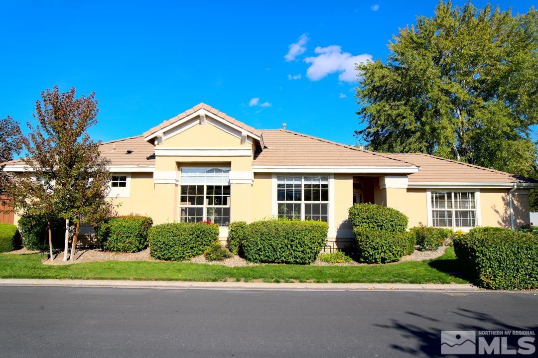 a front view of a house with a yard and potted plants