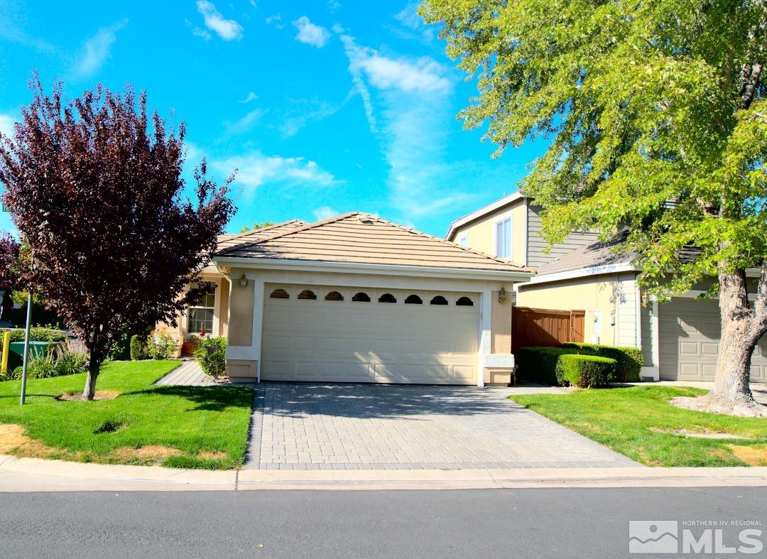 9612 Truckee Meadows Place Reno, NV 89521 - Photo 2 of 29 a view of a white house with a big yard plants and large trees
