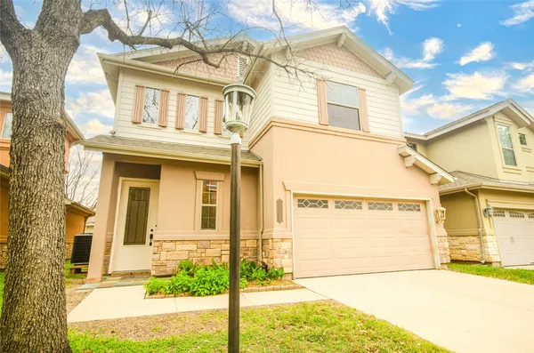 a view of a white house with large windows and a small yard