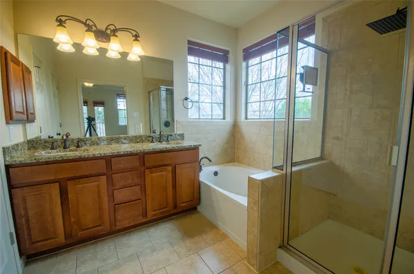 a bathroom with a tub sink shower and mirror