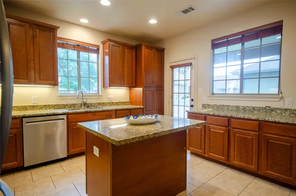 a kitchen with granite countertop sink stove and cabinets