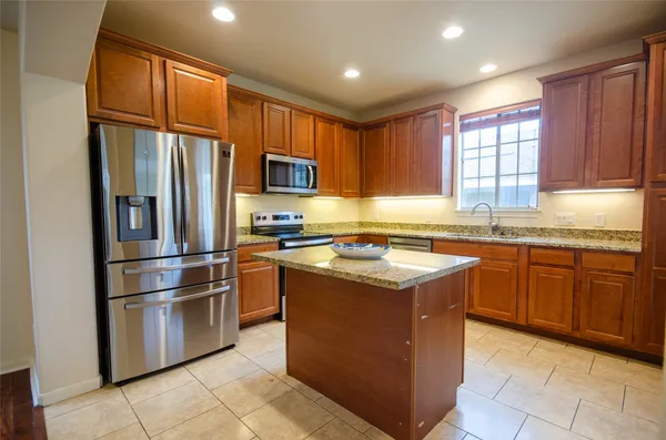 a kitchen with stainless steel appliances granite countertop a refrigerator stove a sink and a microwave
