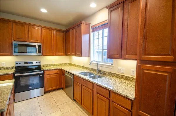 a kitchen with stainless steel appliances granite countertop a sink stove and microwave