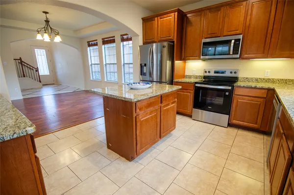 a kitchen with stainless steel appliances granite countertop a stove a sink and a microwave