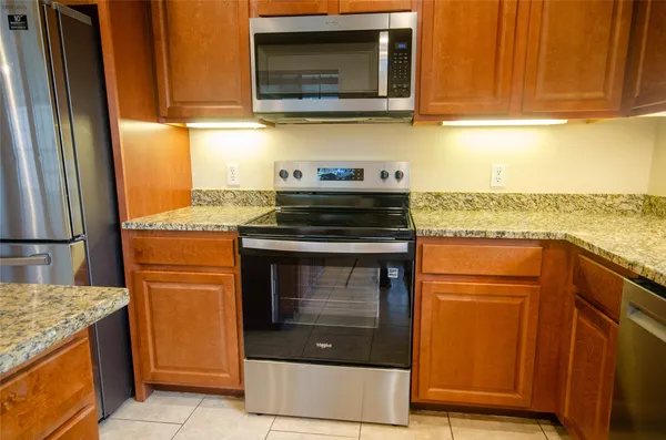 a kitchen with granite countertop cabinets stainless steel appliances and a counter space