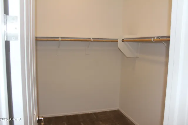 a view of walk in closet with empty racks