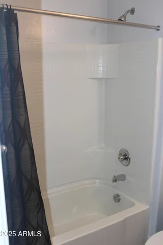 a bathroom with a granite countertop toilet sink and mirror