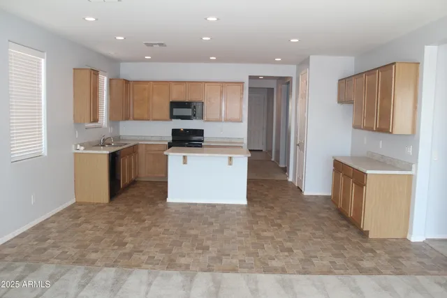 a kitchen with a sink a counter top space stainless steel appliances and cabinets