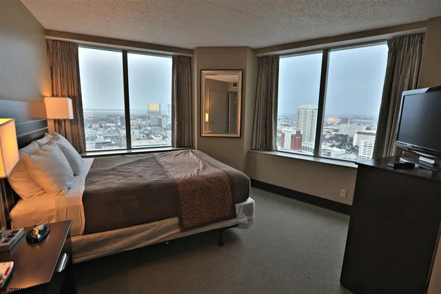 a bedroom with a bed and a large window