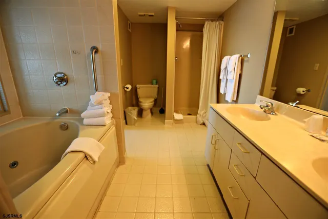 a spacious bathroom with a double vanity sink a mirror and a bathtub