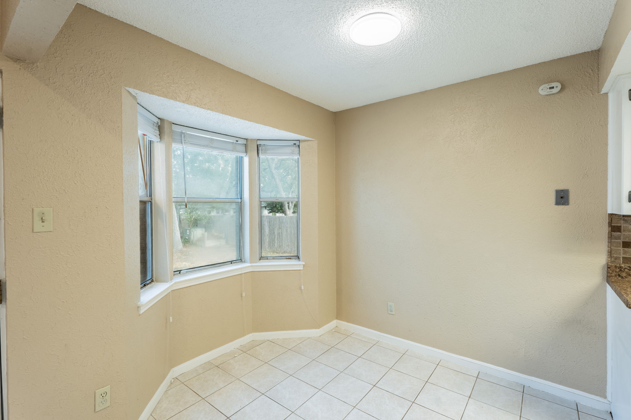 5628 Wagon Train Road Austin, TX 78749 - Photo 10 of 26 A sunny dining nook features tile flooring and a bright bay window overlooking the yard.