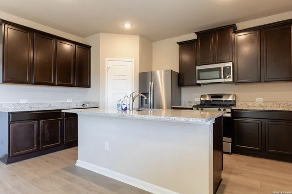 a kitchen with stainless steel appliances granite countertop a refrigerator stove and sink