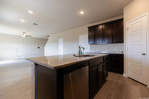 a kitchen with a sink a microwave and cabinets