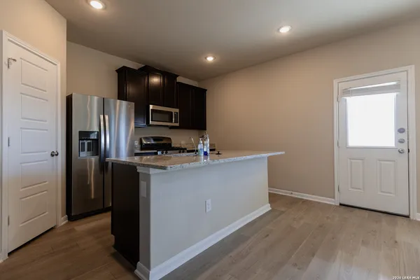 a kitchen with stainless steel appliances granite countertop a refrigerator and a stove top oven