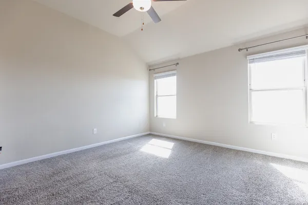 an empty room with a window and a ceiling fan