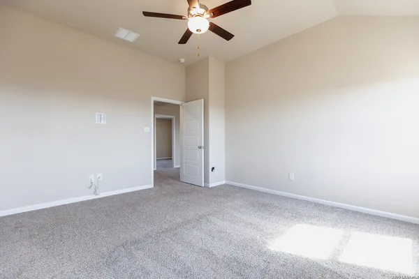 an empty room with a ceiling fan and a window