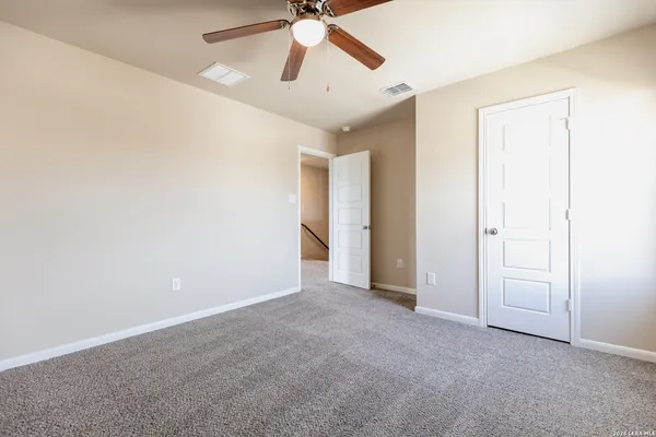 an empty room with chandelier fan