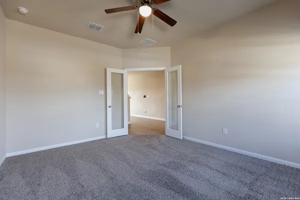 en empty room with ceiling fan and window