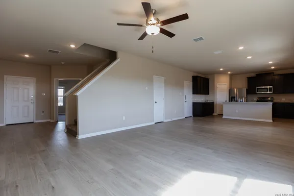 a view of empty room with wooden floor and ceiling fan
