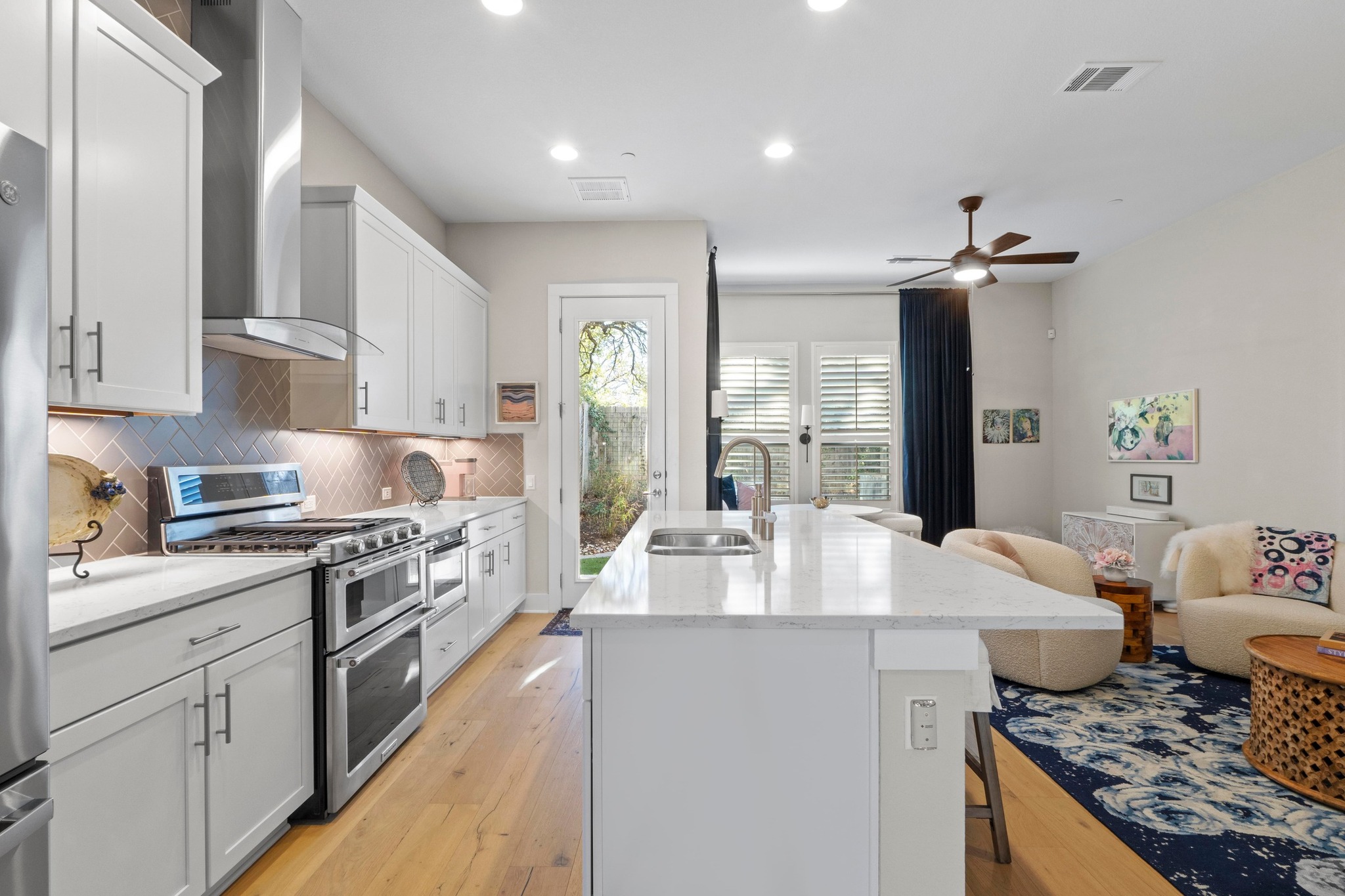 4323 Spicewood Springs Road, Unit 6 Austin, TX 78759 - Photo 40 of 40 Kitchen featuring a kitchen bar, appliances with stainless steel finishes, a kitchen island with sink, open floor plan, and wall chimney exhaust hood