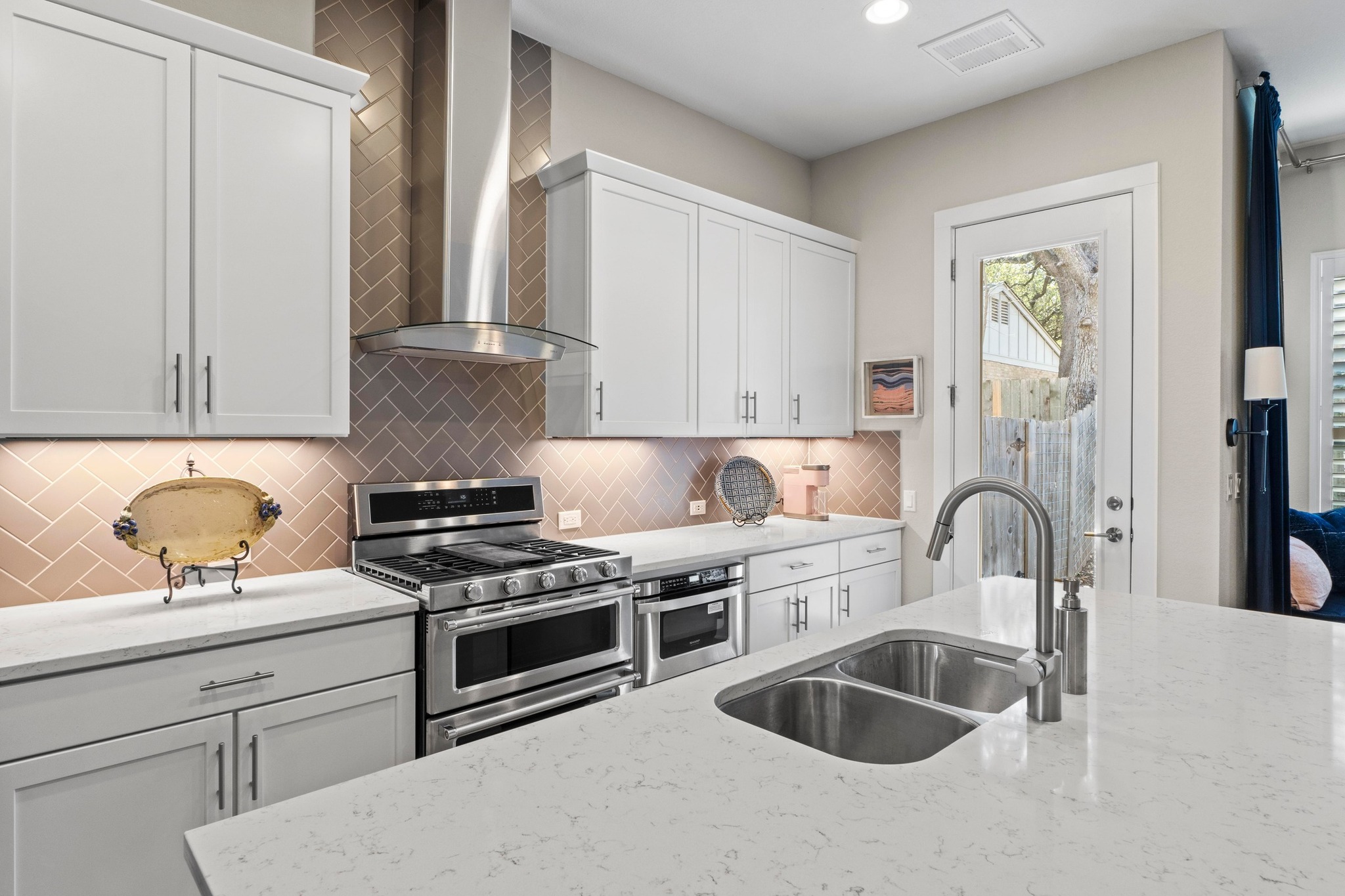 4323 Spicewood Springs Road, Unit 6 Austin, TX 78759 - Photo 11 of 40 Kitchen featuring appliances with stainless steel finishes, wall chimney range hood, white cabinetry, light stone counters, and recessed lighting