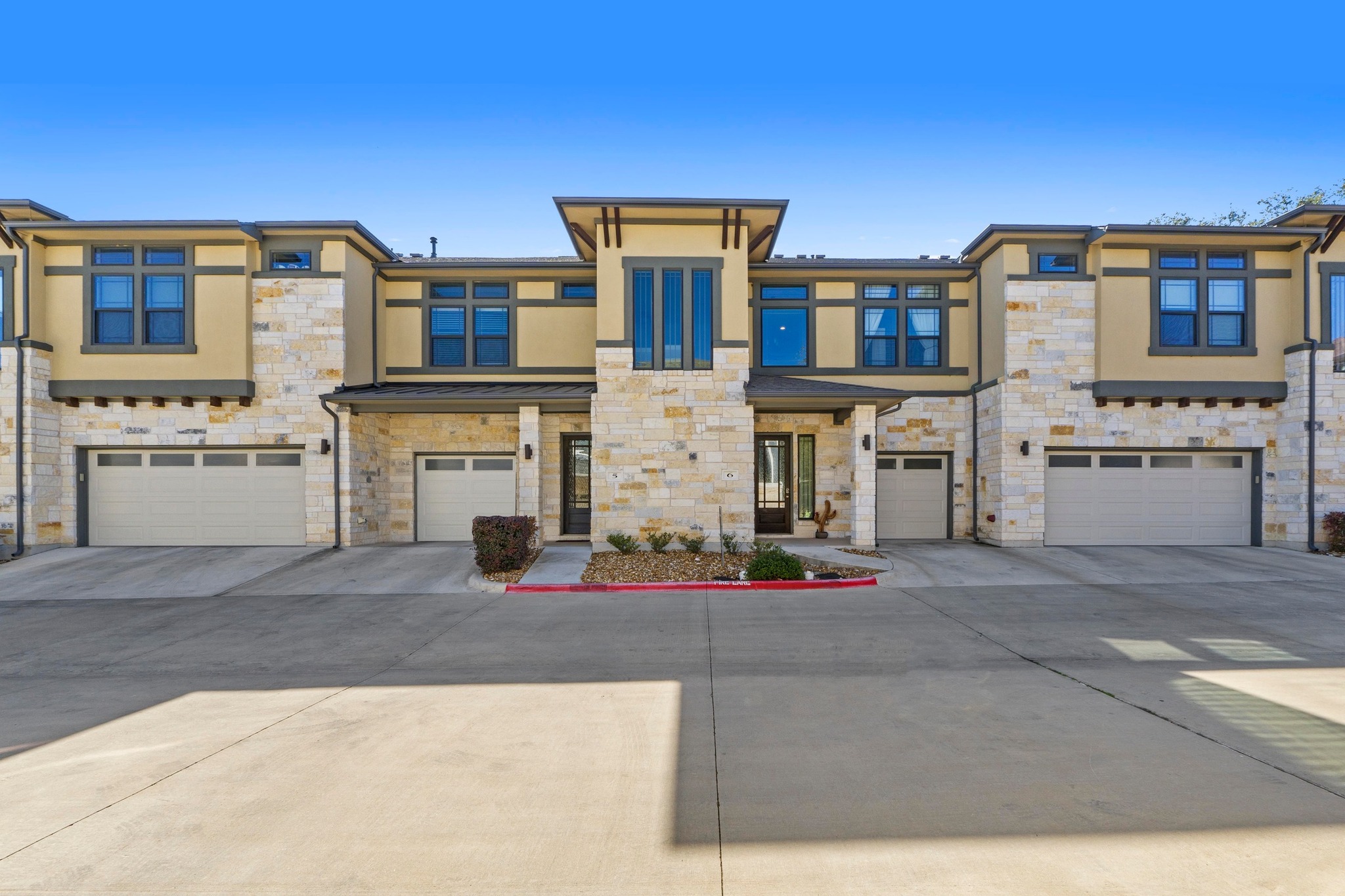 4323 Spicewood Springs Road, Unit 6 Austin, TX 78759 - Photo 3 of 40 View of front of home featuring stone siding, stucco siding, driveway, and a garage