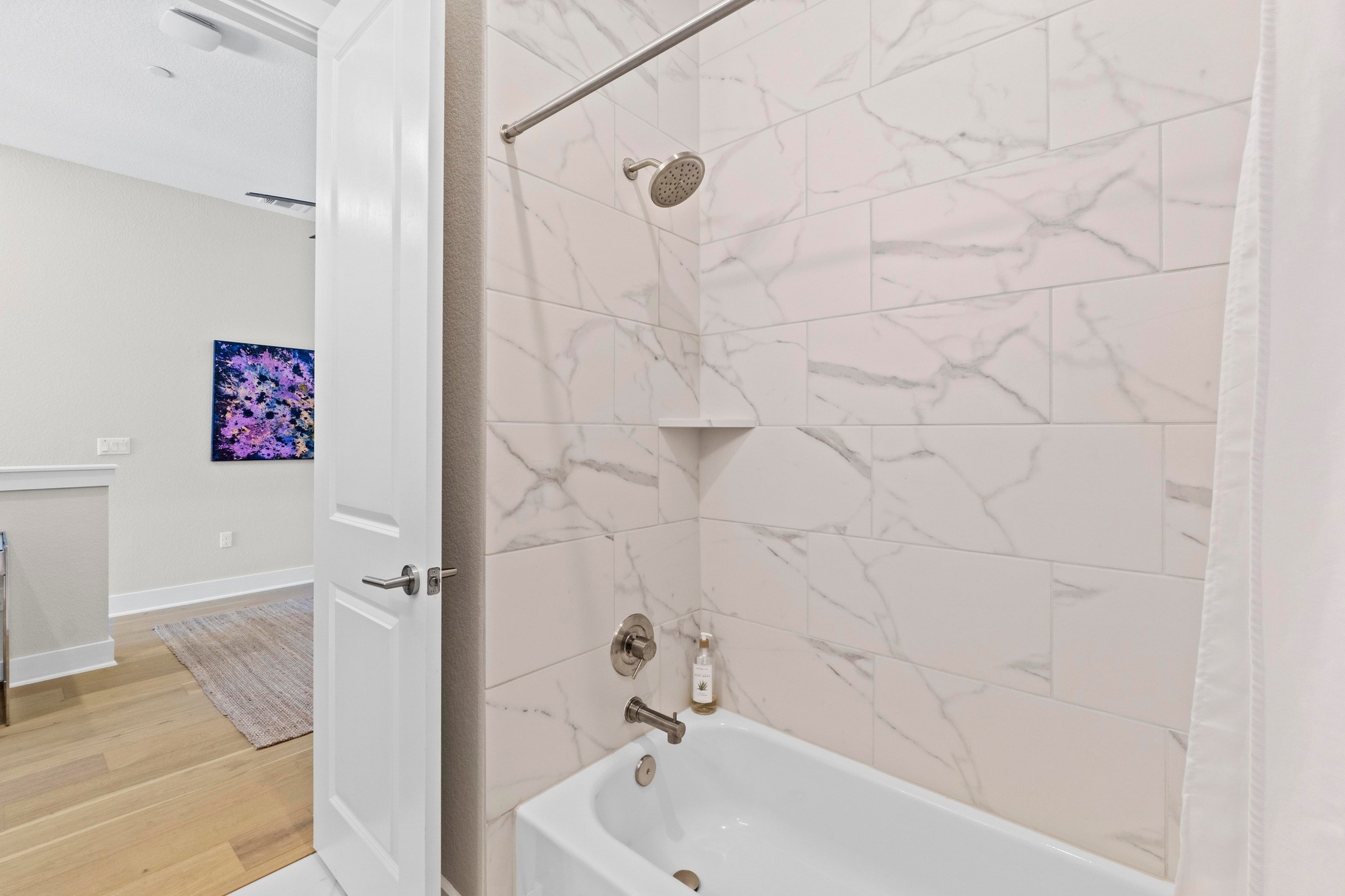 4323 Spicewood Springs Road, Unit 6 Austin, TX 78759 - Photo 35 of 40 Bathroom with shower / bath combination with curtain and wood finished floors