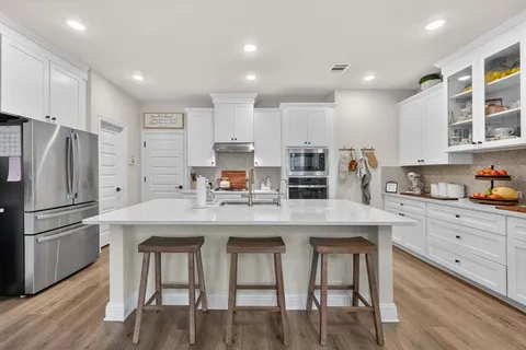 a kitchen with stainless steel appliances granite countertop a white cabinets and a refrigerator