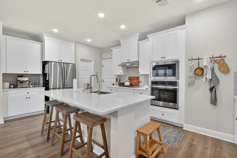 a kitchen with stainless steel appliances a refrigerator and a stove top oven
