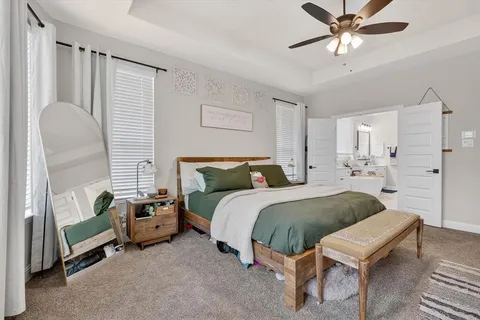 a spacious bedroom with a bed and a chandelier