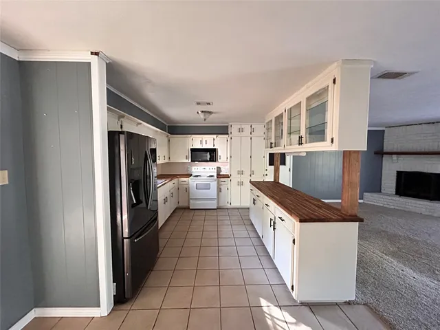 a view of a hallway with a chandelier fan and windows