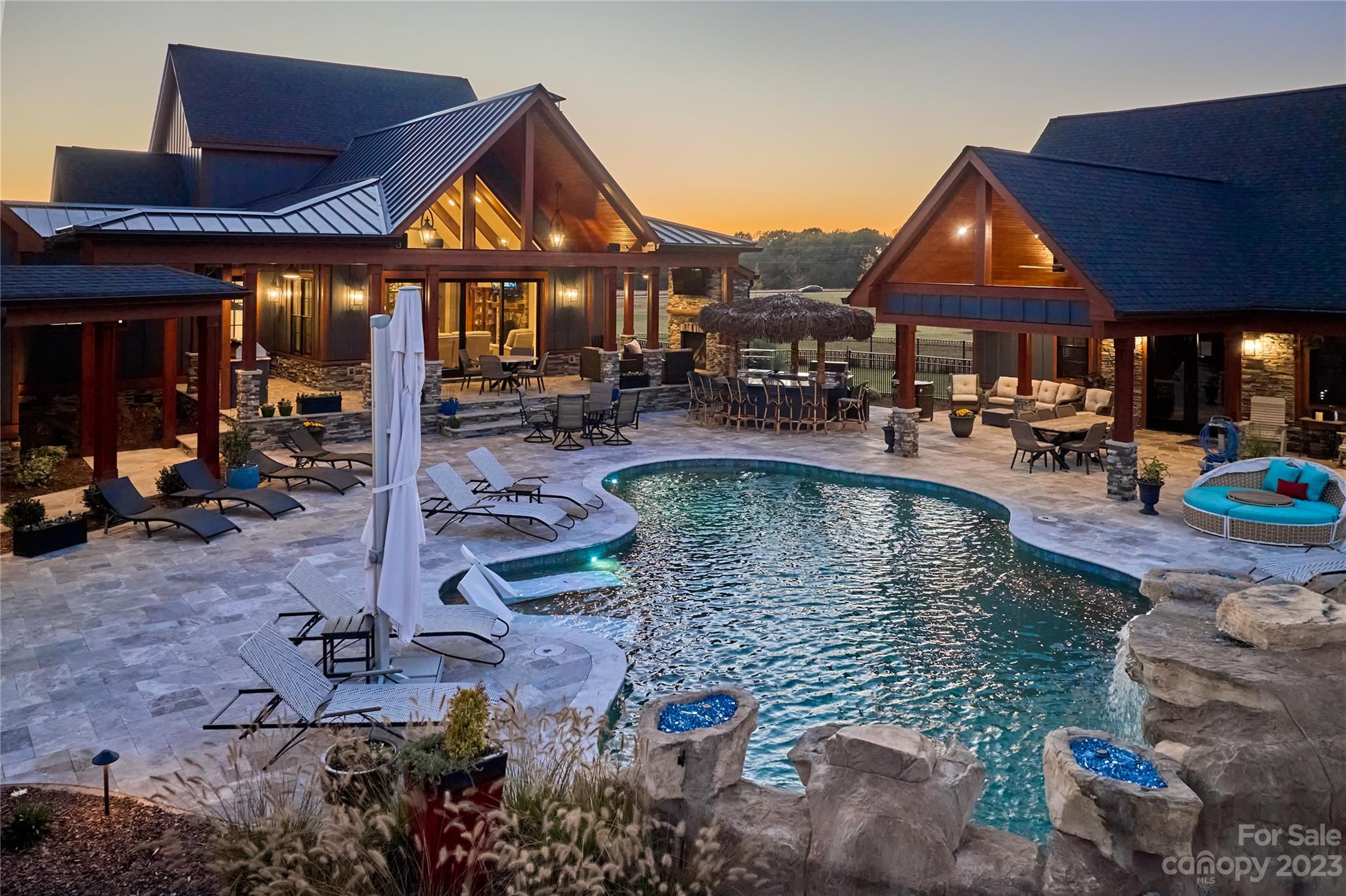 a view of a house with backyard water fountain and sitting area