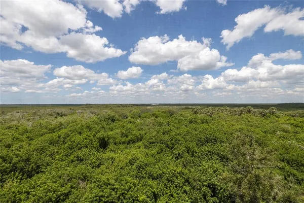 a spacious bedroom with a bed and wooden floor
