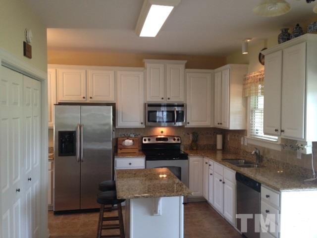1004 Nortonbridge Road Raleigh, NC 27603 - Photo 5 of 13 a kitchen with stainless steel appliances granite countertop a refrigerator a stove a sink and a microwave