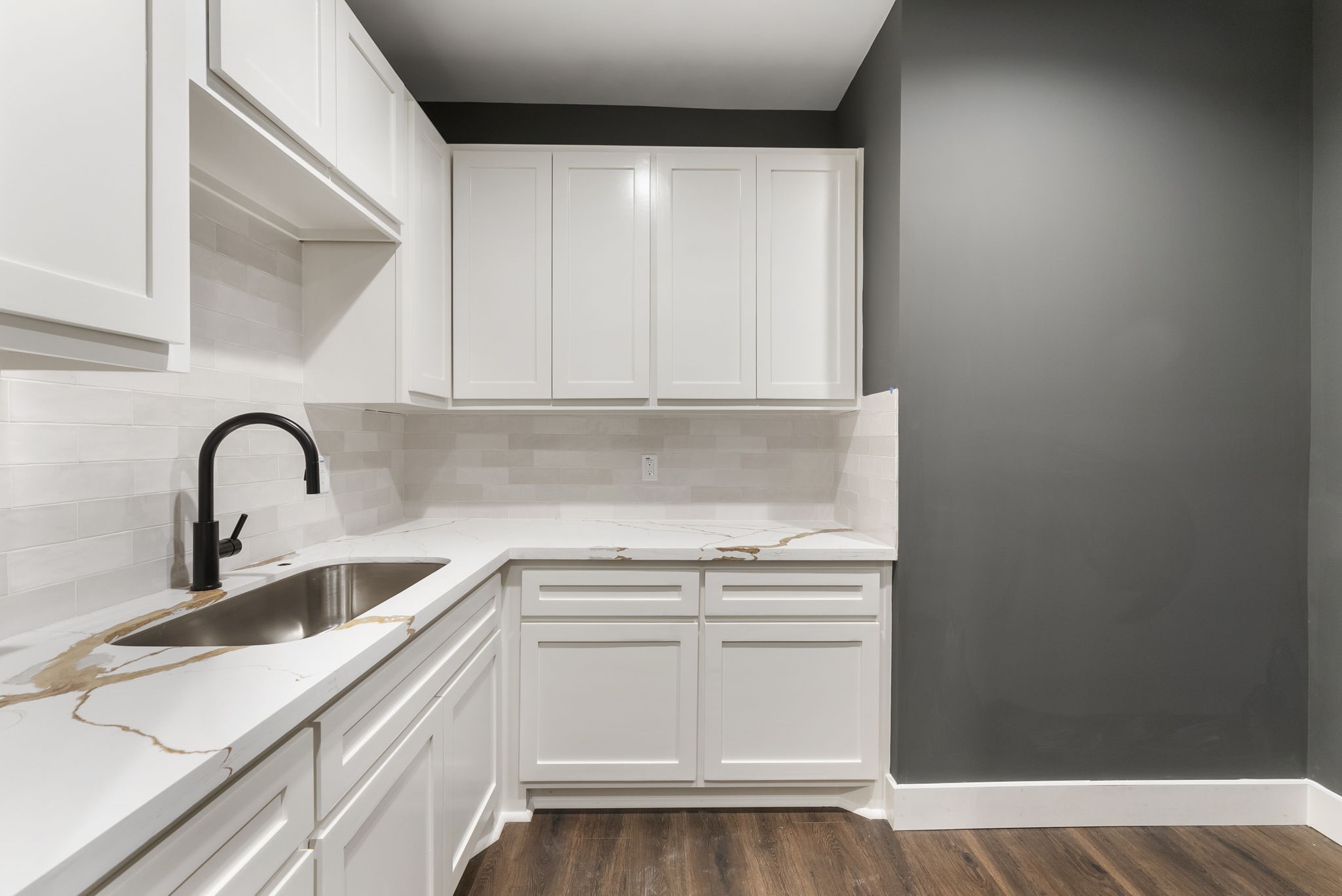29001 Colin Court Waller, TX 77484 - Photo 18 of 47 This dreamy laundry room features sleek white cabinetry with ample storage, over-sized sink, a modern black faucet, and elegant quartz countertops.