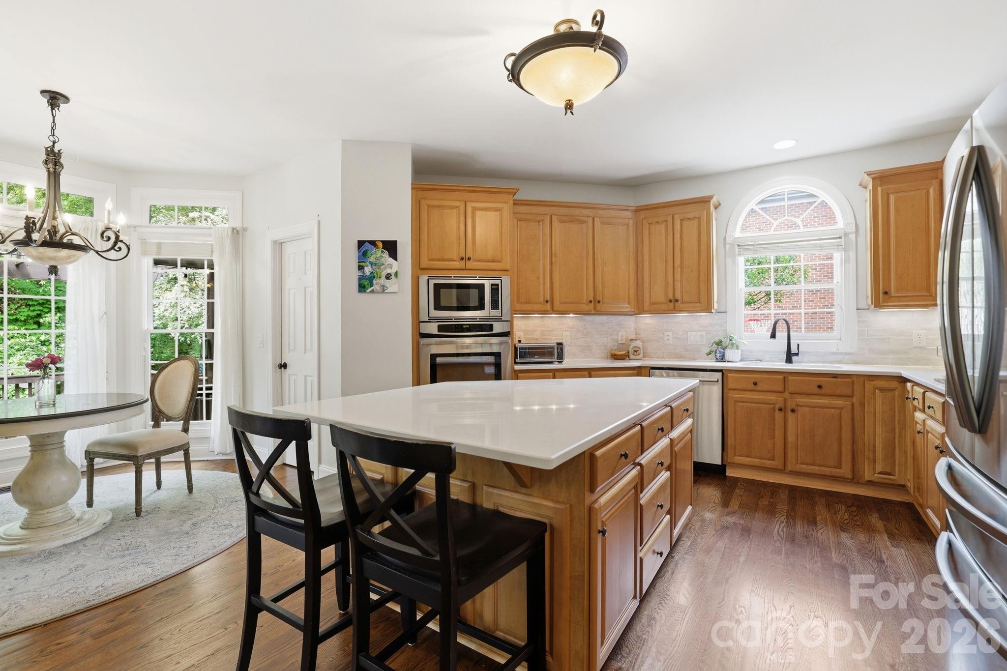 239 Sardis Pointe Road Matthews, NC 28105 - Photo 9 of 47 a kitchen with a table chairs sink and cabinets