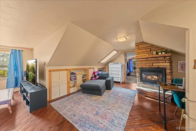 a living room with furniture a flat screen tv and a fireplace