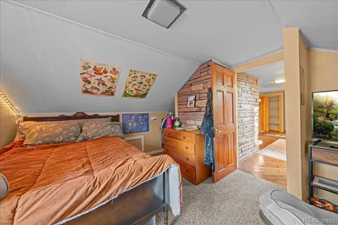 a bedroom with a bed and a flat tv screen on the dresser