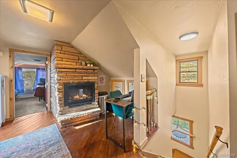 a living room with furniture a fireplace and wooden floor