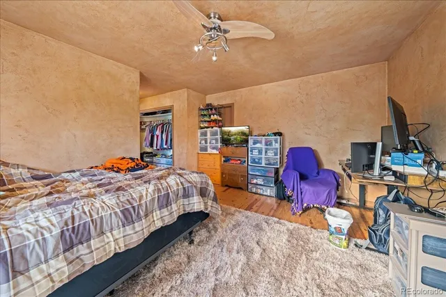 a bedroom with bed and wooden floor