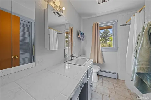 a bathroom with a sink a toilet and a mirror