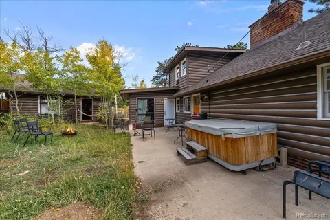 a view of house with backyard and outdoor seating