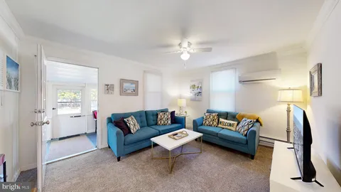 a living room with furniture a ceiling fan and a window