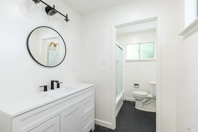 a bathroom with a sink a toilet and a mirror