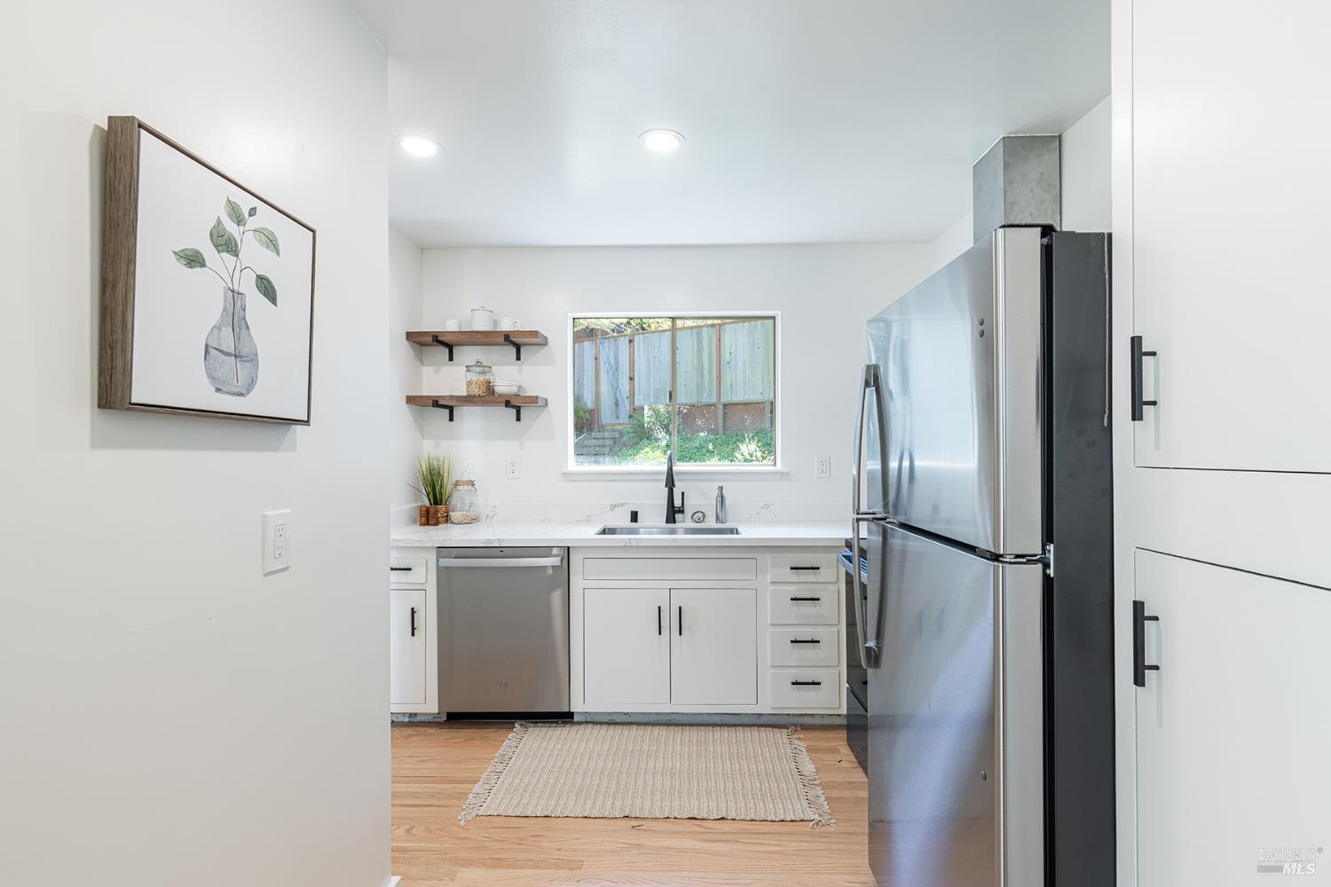 157 Homestead Boulevard Mill Valley, CA 94941 - Photo 7 of 20 a kitchen with stainless steel appliances a refrigerator sink and white cabinets