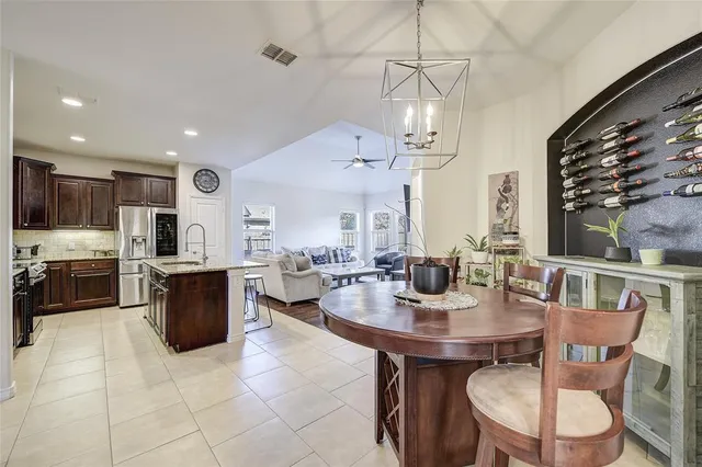 a view of a dining room with furniture a chandelier and kitchen view