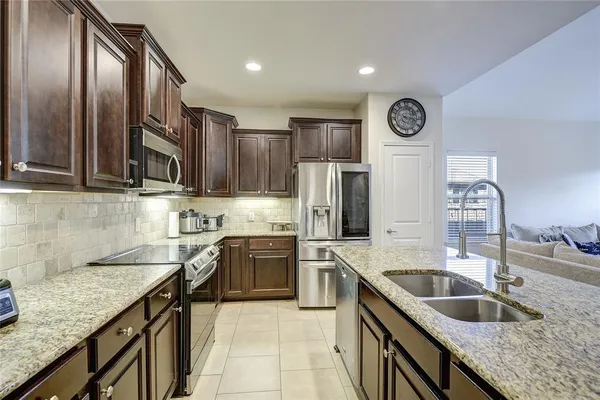 a kitchen with stainless steel appliances granite countertop a sink stove and refrigerator